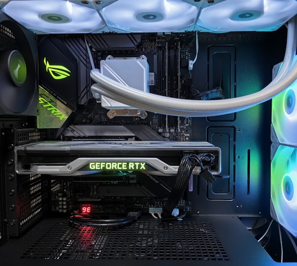 A high-end gaming or performance PC interior equipped with RGB lighting and multiple cooling fans. The graphics card prominently displayed is a GeForce RTX model, with branding visible. The setup includes neatly managed cables and a liquid cooling system.